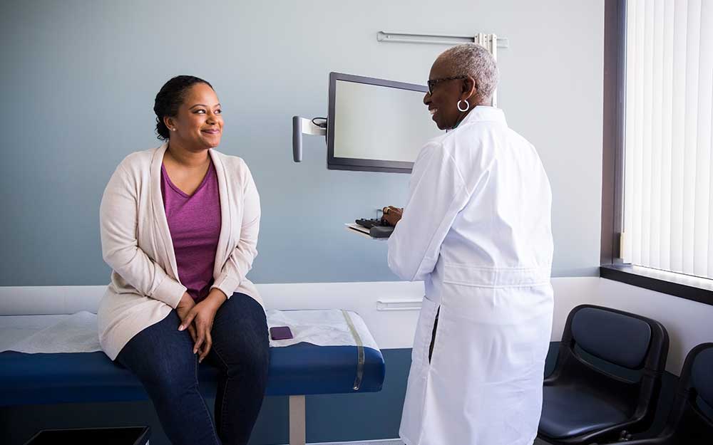 Woman smiling at a doctor in an exam room.